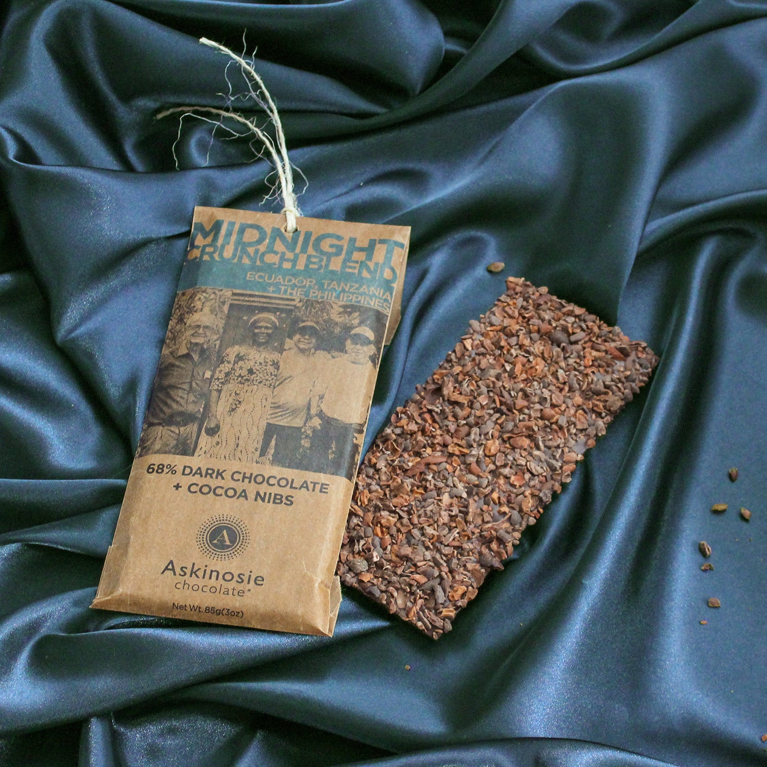 Askinosie Chocolate bar and packaging on a dark navy silk background